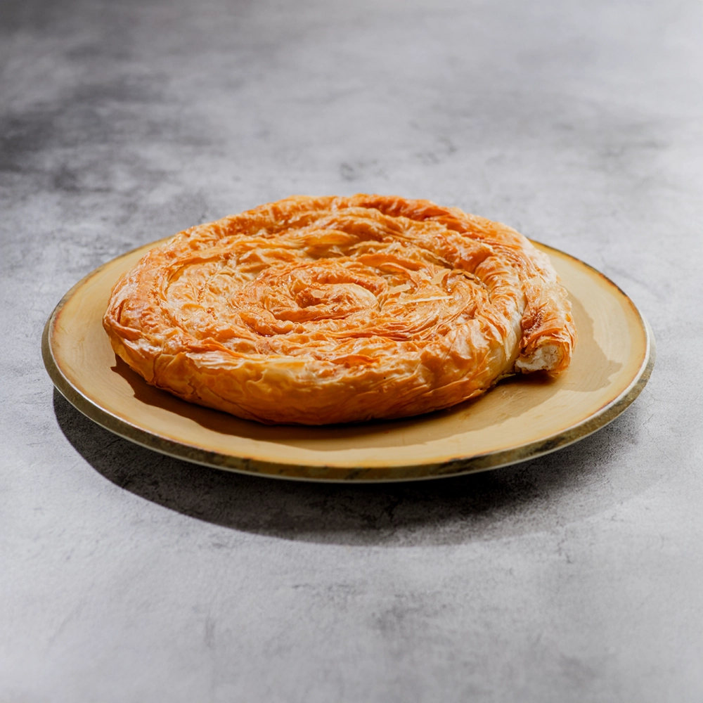 στριφτή πίτα με τυρί σε πιάτο