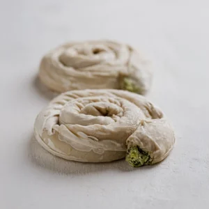 2 νηστίσιμα ατομικά στριφτά με γέμιση σπανάκι σε λευκό φόντο