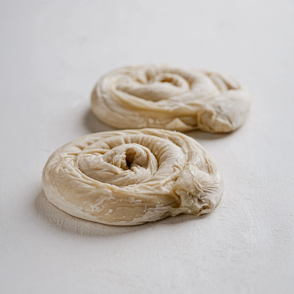 2 ατομικά στριφτά με γέμιση σπανάκι τυρί σε λευκό φόντο